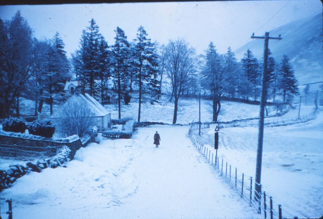Someone walks up the road in winter close to Glenshee Church.