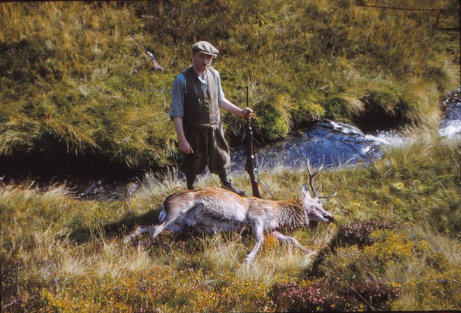 A man on a shoot stands over his prize.