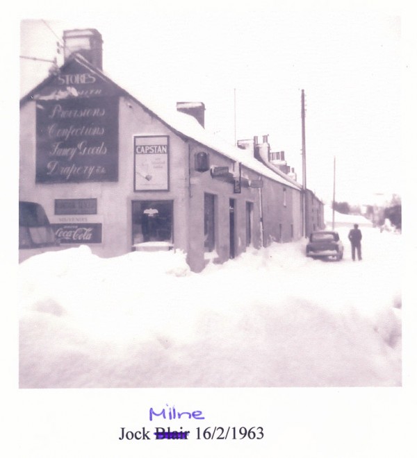 Deep snow covers Kirkmichael Main Street.  In the foreground is Halley's Stores.